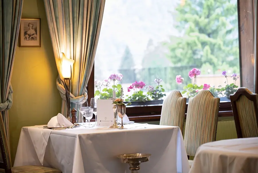 Tisch am Fenster im Restaurant Doldenhorn, draussen Geranien