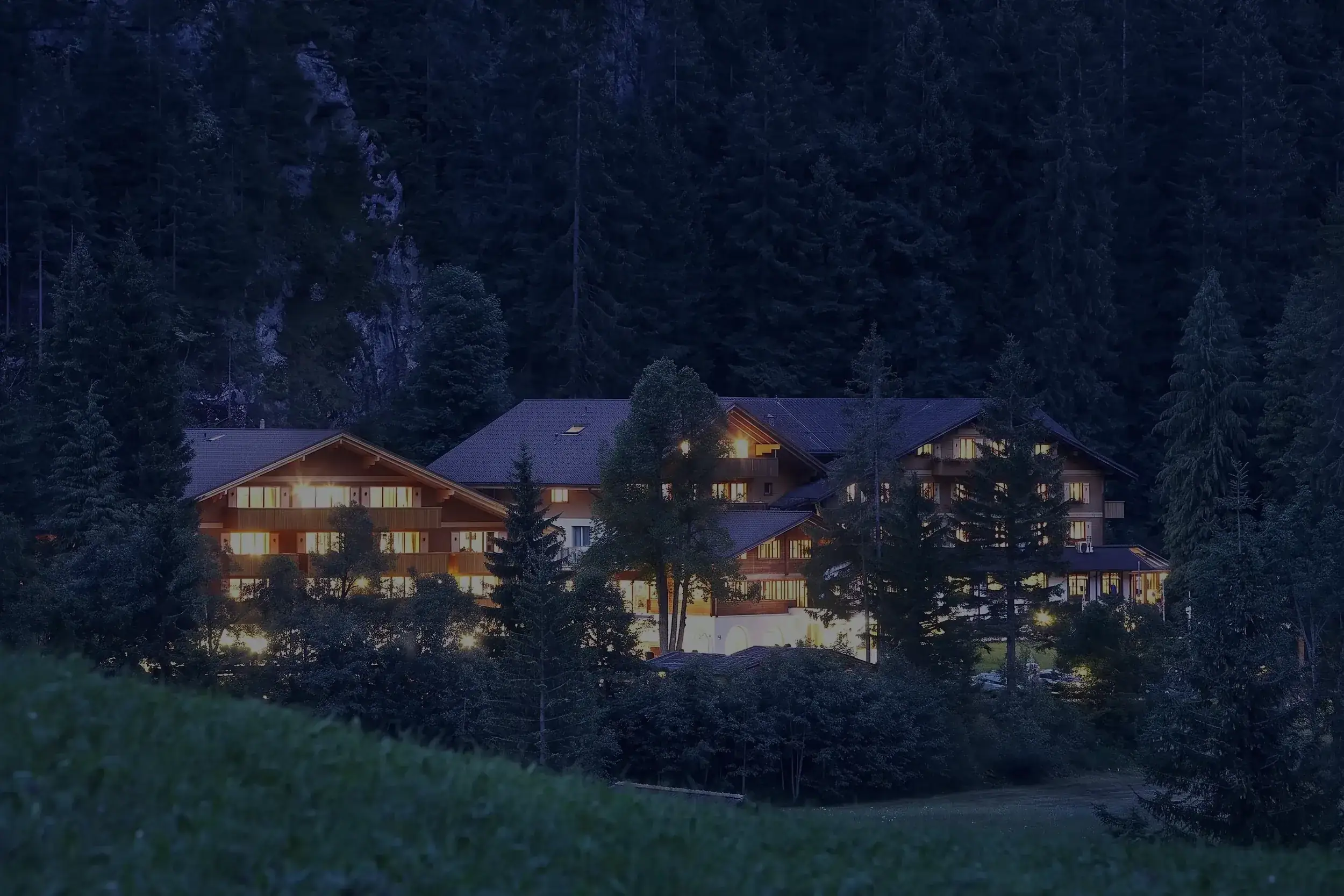 Das Waldhotel Doldenhorn in der Dämmerung, alle Fenster erleuchtet