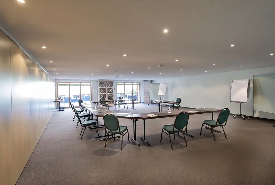 Seminarraum mit Tischen im Rechteck und Flipchart