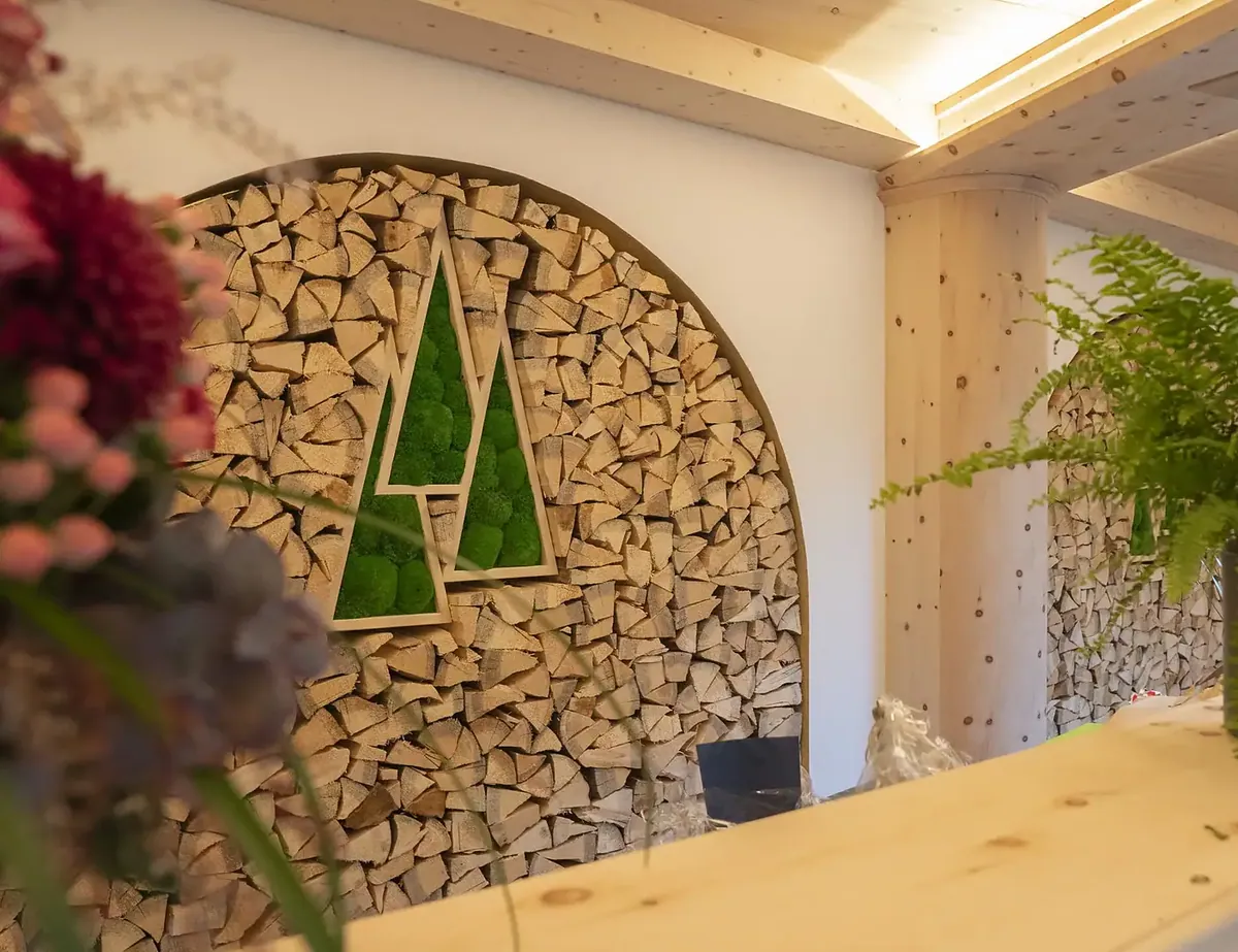 Der Empfang des Waldhotel Doldenhorn mit den drei Tannen an der Holzwand